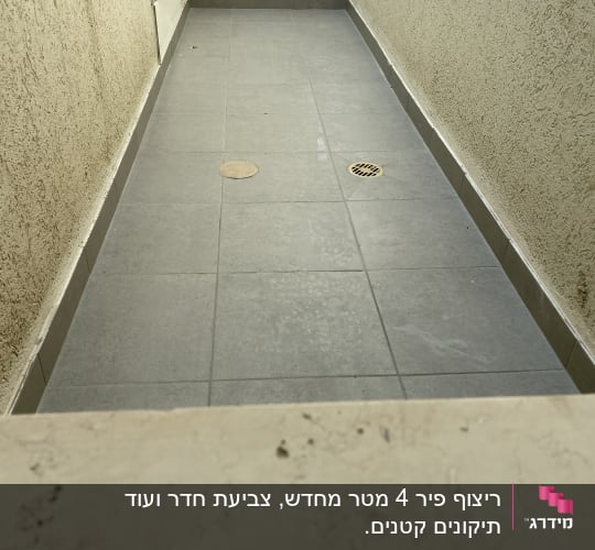 רצפת אריחים אפורה עם פתחי ניקוז